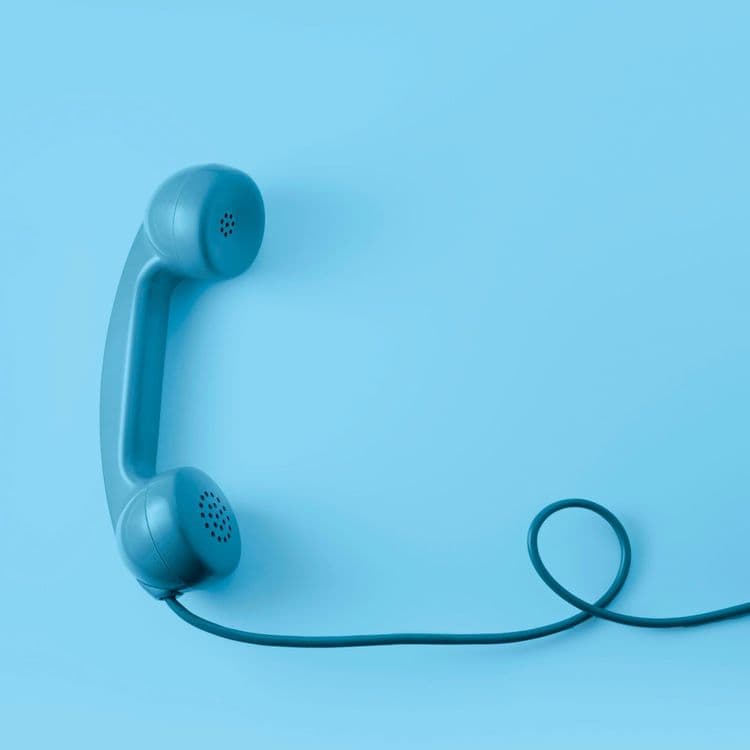 Blue phone handset with cord on blue background