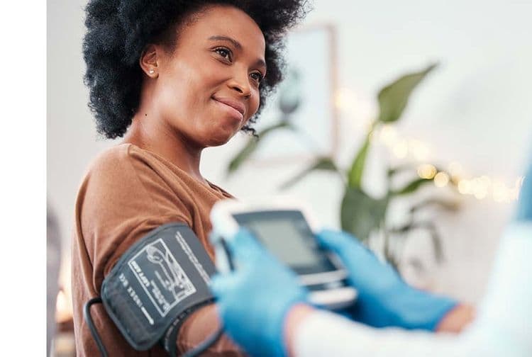 Woman having her blood pressure taken by a Bluecrest Health Assessment Specialist