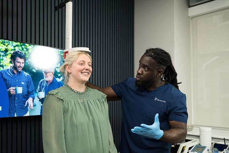 Bluecrest employee measures a patient's height.
