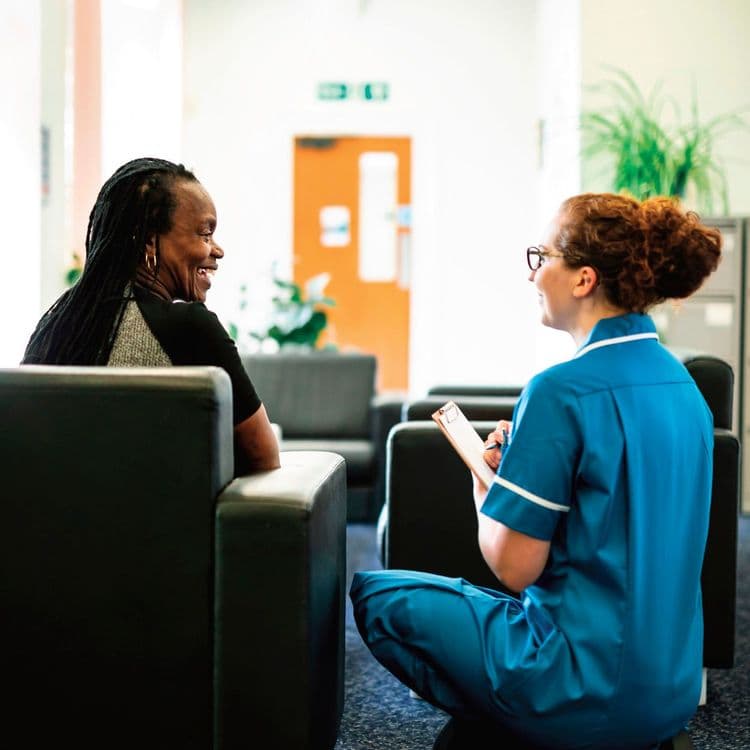 Bluecrest Health Assessment Specialist talking to a lady in a hotel Reception